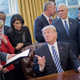 The president shoots a finger gun at budget director Mick Mulvaney after signing an executive order. Image via AP Photo.